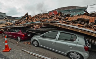 Un immeuble est effondré sur des véhicules en stationnement après le séisme de magnitude 6,3 à Christchurch, Nouvelle-Zélande, le 22 février 2011.