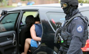 Cette photo, remise par la police de Nouvelle-Galles du Sud le 10 décembre 2015, montre un homme (g) qui se fait arrêter dans le cadre d'une enquête antiterrorisme à Sydney