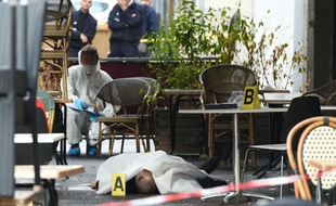 Des médecins légistes de la police recueillent des indices près du corps d'un homme tué dans une fusillade devant un bar, le 13 septembre 2015 à Marseille