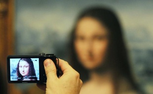 Un visiteur photographie une copie authentifiée de la Joconde de Léonard de Vinci présentée au musée du Prado à Madrid le 21 février 2012