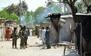 Des soldats parlent avec des habitants de Zabarmari, un village proche de Maiduguri victime d'une attaque de Boko Haram, le 3 juillet 2015