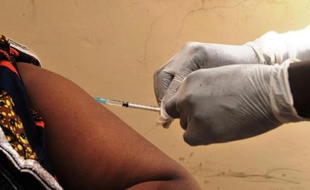 Une femme reçoit un vaccin le 10 mars 2015 à Conakry en Guinée lors des premiers essais de vaccin VSV-EBOV contre le virus Ebola