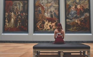 Illustration d'une personne admirant des œuvres d'art dans un musée.