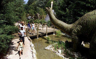 Des visiteurs regardent un brontosaure animé, le 11 juin 2003 à Dolancourt dans le parc Nigloland.