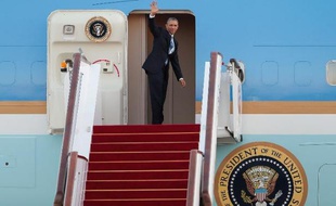 Le président américain Barack Obama salue la foule depuis l'aéroport de Pekin avant de s'engouffrer dans l'avion qui va le mener en Birmanie, le 12 novembre 2014