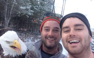 Deux Canadiens réalisent un selfie après avoir sauvé un aigle, coincé dans un piège.