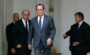 Le président François Hollande (c) et le ministre de la Défense Jean-Yves Le Drian (g) à la sortie du Conseil des ministres, le 18 novembre 2015 à Paris