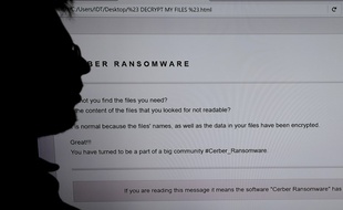 Illustration d'un ingénieur en informatique devant l'écran d'un ordinateur infesté par un virus en 2016.