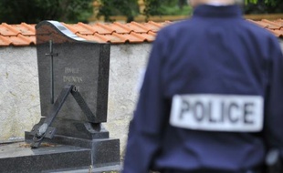 Policier devant une tombe dégradée le 4 août 2015 dans le cimetière de Labry