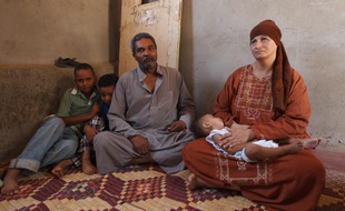 Une famille endettée aperçoit à peine la pyamide de Kheops de sa maison, cachée maintenant par un mur érigé en 2006, Égypte.