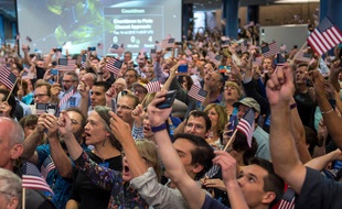 Drapeaux américains brandis pour saluer le succès de New Horizons le 14 juillet 2015 à Laurel, Maryland.