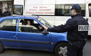 Un policier français arrête une voiture à Lyon le 14 mars 2014 pour vérifier son pot d'échappement