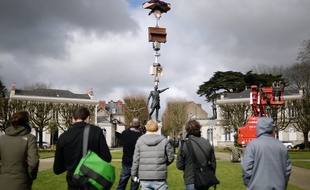 People look at an ephemeral creation of Japanese artist Tatzu Nishi above the statue of French General Mellinet on March 13, 2015 in Nantes, western France, 4 months before the "A journey to Nantes" (Le Voyage a Nantes) art festival. The event will run from July 3 to August 30, 2015. AFP PHOTO / JEAN-SEBASTIEN EVRARD