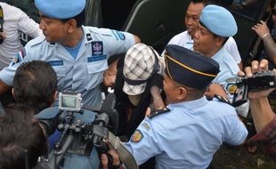 L'Australienne Schapelle Corby est escortée par la police indonésienne après sa libération sous conditions de la prison de Kerobokan, sur l'île de Bali, le 9 février 2014.