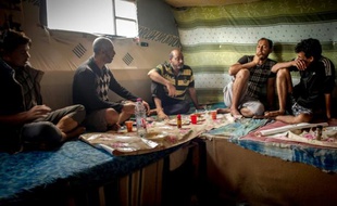 Des migrants afghans et pakistanais déjeunent dans la "new jungle", le 14 août 2015 à Calais