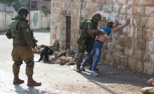 Des soldats israéliens fouillent un Palestinien, le 29 octobre 2015 à Hébron, en Cisjordanie