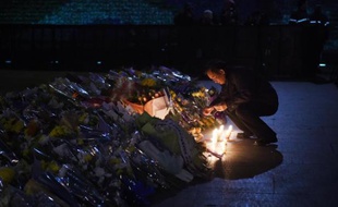 Un homme allume le 2 janvier 2015 à Shanghai une bougie à l'endroit où un mouvement de foule a provoqué la mort de 36 personnes venues fêter la nouvelle année