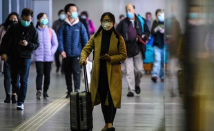 Des passagers portent des masques à l'aéroport de Hong Kong, le 3 février 2020.
