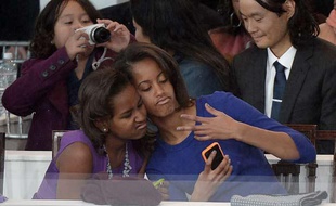 Les filles du président américain, Sasha (G) et Malia (D) Obama, prennent un «selfie» lors de la cérémonie d'investiture de leur père le 21 janvier 2013 à Washington.