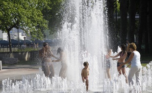 A Lyon, un jour de canicule de 2010, des habitants tentent de trouver un peu de fraîcheur en pataugeant dans une fontaine publique.