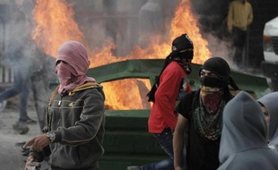 Des jeunes Palestiniens masqués lors de heurts avec des policiers israéliens au amp de Chouafat, à Jérusalem-Est, le 5 novembre 2014