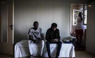 Des immigrants soudanais posent le 13 février 2015 dans une chambre d'une ancienne caserne de gendarmerie transformée en centre d'accueil pour migrants, à Pouilly-en-Auxois
