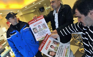 Des policiers distribuent des affiches à l'effigie du petit Antoine disparu à Issoire (Puy-de-Dôme) le 11 septembre 2008.