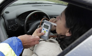 Une automobiliste subit un contrôle d'alcoolémie à l'aide d'un alcootest numérique.