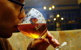 Un étudiant déguste une bière Leffe à Bruxelles.