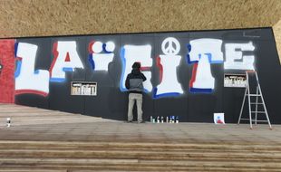 Un street-artiste réalise une fresque "laïcité" sur la Place de la laïcité à Paris le 9 décembre 2015.