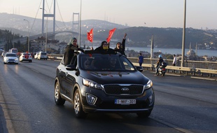Une famille défile avec des drapeaux turcs près du pont du Bosphore à Istanbul.