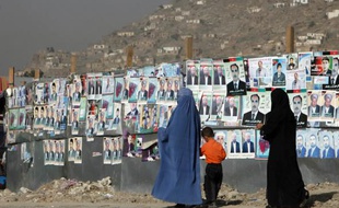 Des femmes afghanes passent devant des affiches électorales à Kaboul, Afghanistan.