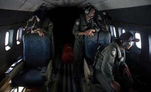 TO GO WITH: MALAYSIA-CHINA-VIETNAM-MALAYSIAAIRLINES-TRANSPORT-ACCIDENT,FOCUS BY SHANNON TEOH This picture taken on March 15, 2014 shows crew members looking outside windows from a Malaysian Air Force CN235 aircraft working during a search and rescue (SAR)Des membres de l'aviation malaisienne scrutent la mer lors des recherches le 15 mars 2014 au dessus du détroit de Malacca