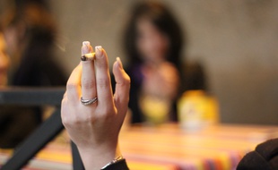 Illustration d'une femme tenant une cigarette à la main.