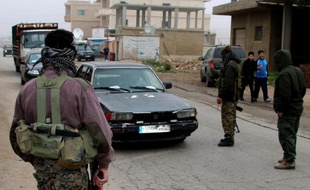 Des Chiites armés contrôlent des véhicules à Bazzalié, près de la frontière syrienne, après l'exécution d'un policier libanais par le Front Al-Nosra, le 6 décembre 2014
