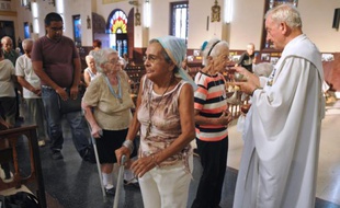 Le père cubain Lusarreta (d) donne la communion à ses fidèles, lors d'une messe à l'Eglise de La Milagrosa, le 15 septembre 2015 à La Havane