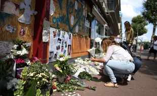 Devant le bar à Rouen, des passants rendent hommage aux 14 victimes du Cuba Libre, un an après les faits en 2017.