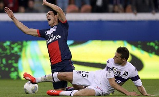 L'attaquant du PSG Edinson Cavani taclé par le défenseur toulousain Uros Spajic, le 28 septembre 2013, au Parc des Princes.