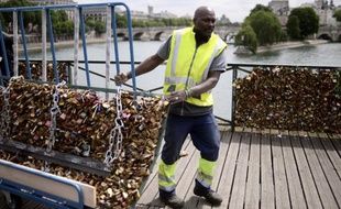 Un employé enlève les "cadenas d'amour" le 1er juin 2015 sur le Pont des Arts, à Paris