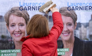 Une militante colle une affiche électorale pour la candidature de Laurence Garnier (LR) aux municipales 2020 à Nantes.