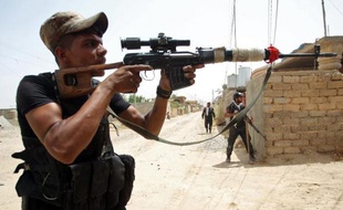 Des combattants chiites irakiens affrontent des jihadistes du groupe Etat islamique (EI) pour le contrôle de la ville de Baïji, sur l'axe entre Bagdad et Mossoul, le 8 juin 2015