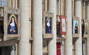 De GàD les portraits de Ste Marie Alphonsine Ghattas, Ste Emilie de Villeneuve, Ste Maria Cristina et Ste Mariam Bawardy accrochés à la basilique Saint Pierre le 17 mai 2015 à Rome