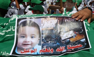 L'image du bébé palestinien brûlé dans un incendie criminel portée par des enfants pendant une manifestation. Des extrémistes juifs sont soupçonnés.