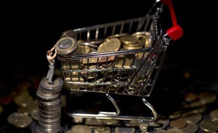 Photo d'illustration montrant une figurine sur des pièces de monnaie et un mini charriot