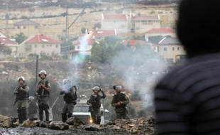Des forces de sécurité israéliennes tirent des gaz lacrymogènes lors d'affrontements avec des palestiniens à Kfar Qaddum, près de Naplouse le 31 octobre 2014