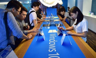 Des visiteurs dans un point de vente de Microsoft à Séoul découvrent Windows 10 le 29 juillet 2015, quelques heures après le lancement de la nouvelle version du système opératif