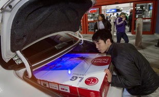 Un consommateur fait rentrer un écran TV dans son coffre lors du "Black Friday", le 27 novembre 2014, en Virginie (USA).