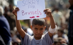 «Désolé pour Bruxelles», lit-on sur la pancarte d'un jeune réfugié syrien, dans le camp d'Idomeni, en Grèce, le 22 mars 2016.