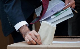 Un homme insère son bulletin dans l'urne, dans un bureau de vote de Bogota, le 9 mars 2014