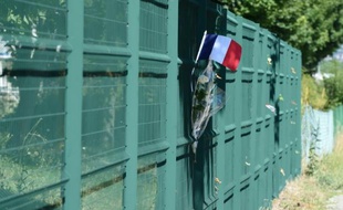 Un drapeau et des fleurs déposés le 28 juin 2015 à l'endroit où a été placée la tête de l'homme décapité à Saint-Quentin-Fallavier